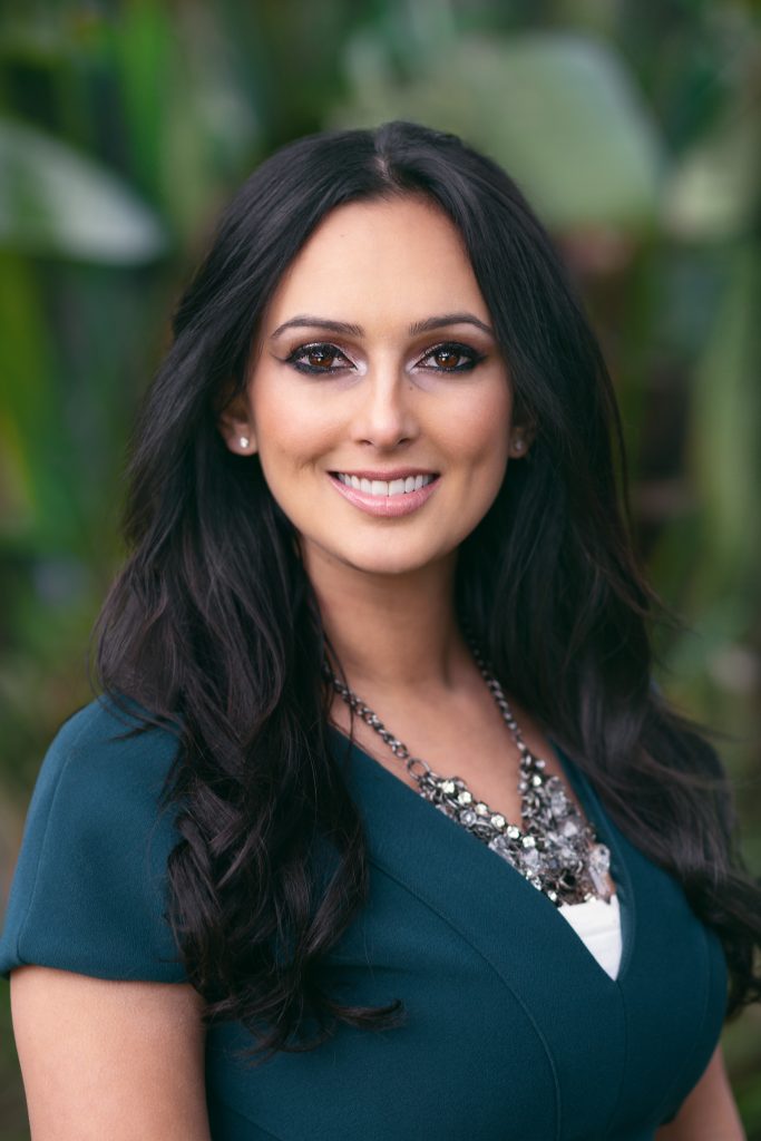 Woman wearing a teal professional top for a business headshot