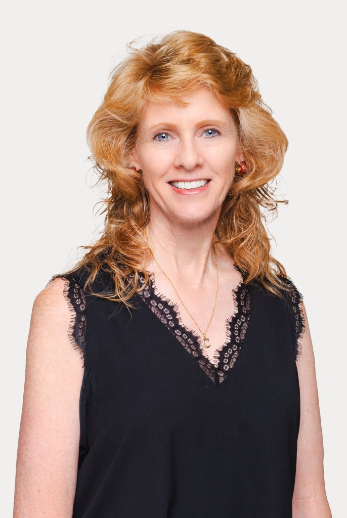 Professional business headshot of a woman against a light studio background