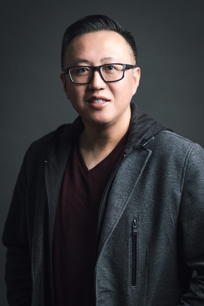 Casual professional headshot of a man wearing glasses and a jacket