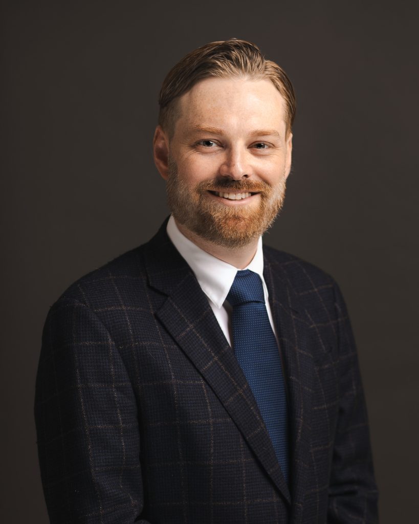 Corporate headshot of a man wearing a suit and tie