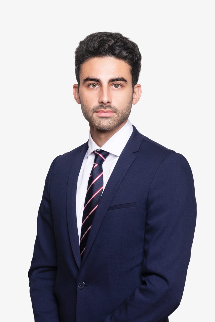 Corporate headshot of a man wearing a navy suit and tie