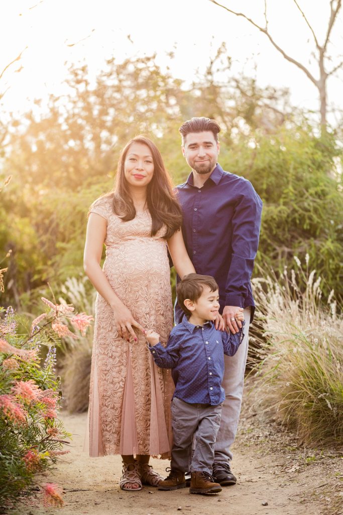Outdoor maternity portrait of an expectant mother with her partner and young son