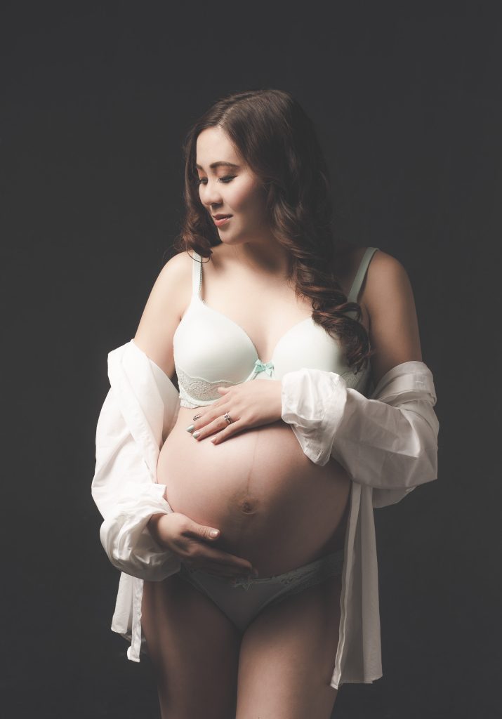 Studio maternity portrait with a white shirt and simple lingerie styling