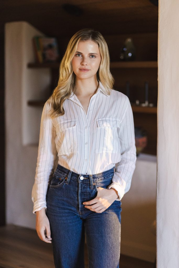 Natural environmental portrait of a woman standing indoors