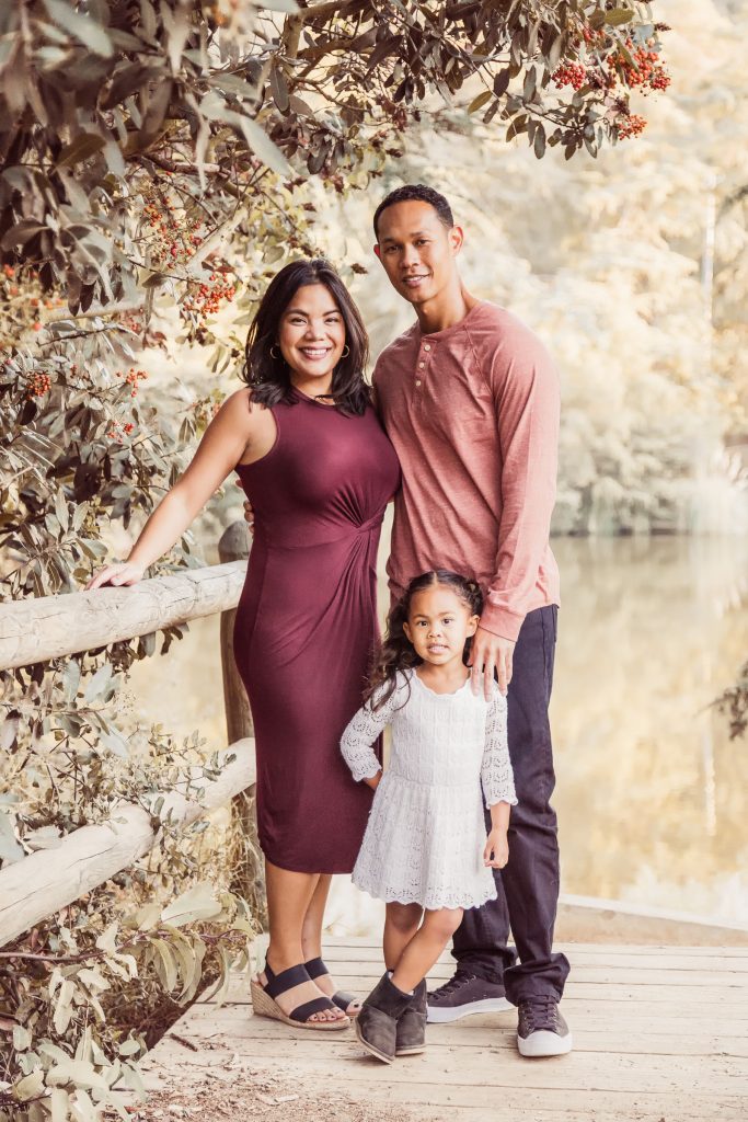 Outdoor family portrait of parents with their young daughter