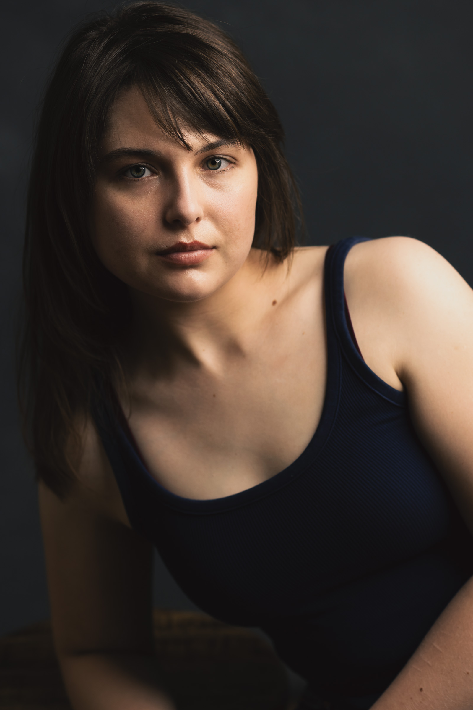Dramatic theatrical headshot of an actress with dark cinematic lighting