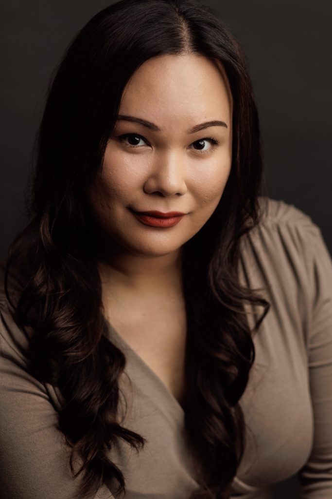 Dramatic theatrical headshot of an actress with dark background